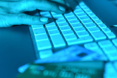 Die Abzocke bei Facebook durch Klon-Profile nimmt zu. Zu sehen ist eine Hand auf einer Tastatur, daneben Kredikarten