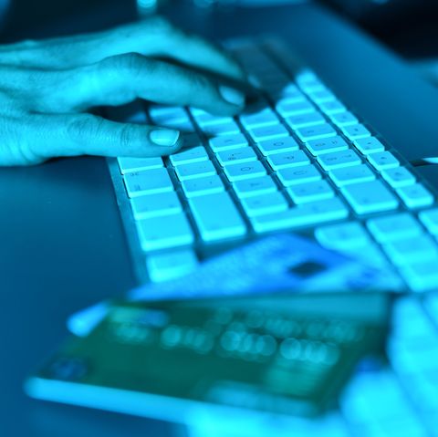 Die Abzocke bei Facebook durch Klon-Profile nimmt zu. Zu sehen ist eine Hand auf einer Tastatur, daneben Kredikarten