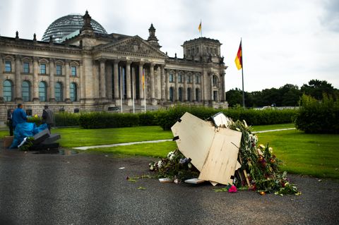 Blumenschmuck, Kerzen, Trauerkränze, ein Sarg und Holzkreuze - alles zusammengekehrt und bereit für den Abtransport