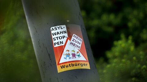 Ein Aufkleber "Asyl-Wahn Stoppen - Nein zum Heim - Wutbürger" klebt an einem Laternenmast in unmittelbarer Nähe des Leonardo-Hotel in Freital in Sachsen. Dort wurden bereits 100 Flüchtlinge untergebracht.