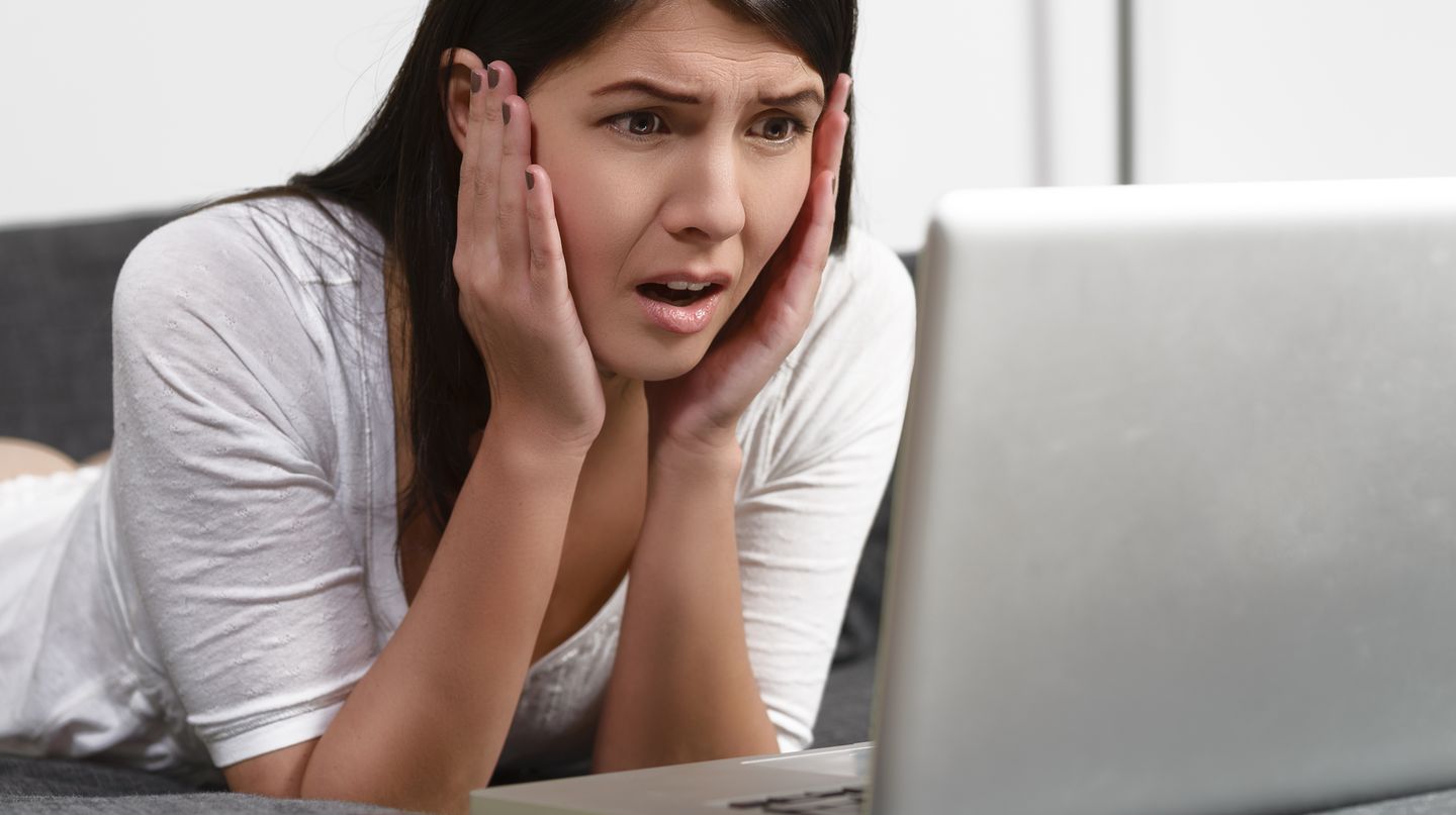 Eine Frau starrt entsetzt auf den Bildschirm. Mit Gmail kann sie nun die zu früh verschickte Mail zurückholen.