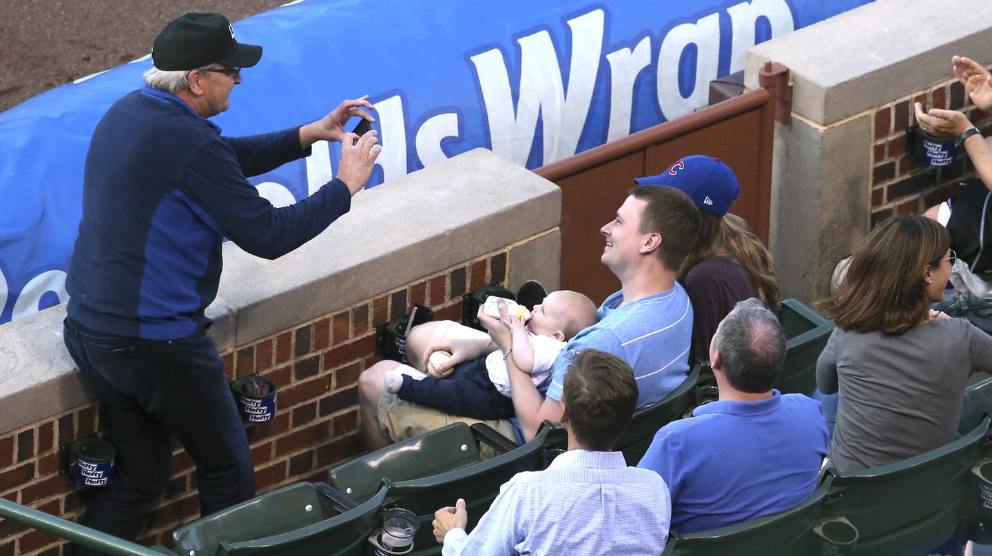 Nach dem spektakulären Fann fotgrafiert ein Mann Baseballfan Keith Hartley und dessen Baby.