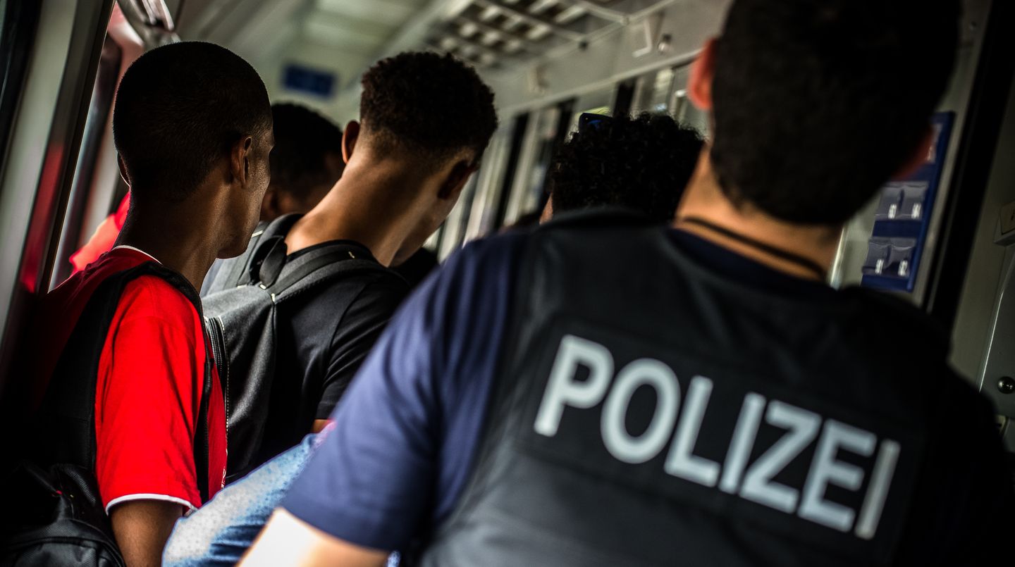 Ein Bundespolizist kontrollieren Reisende in einem Zug
