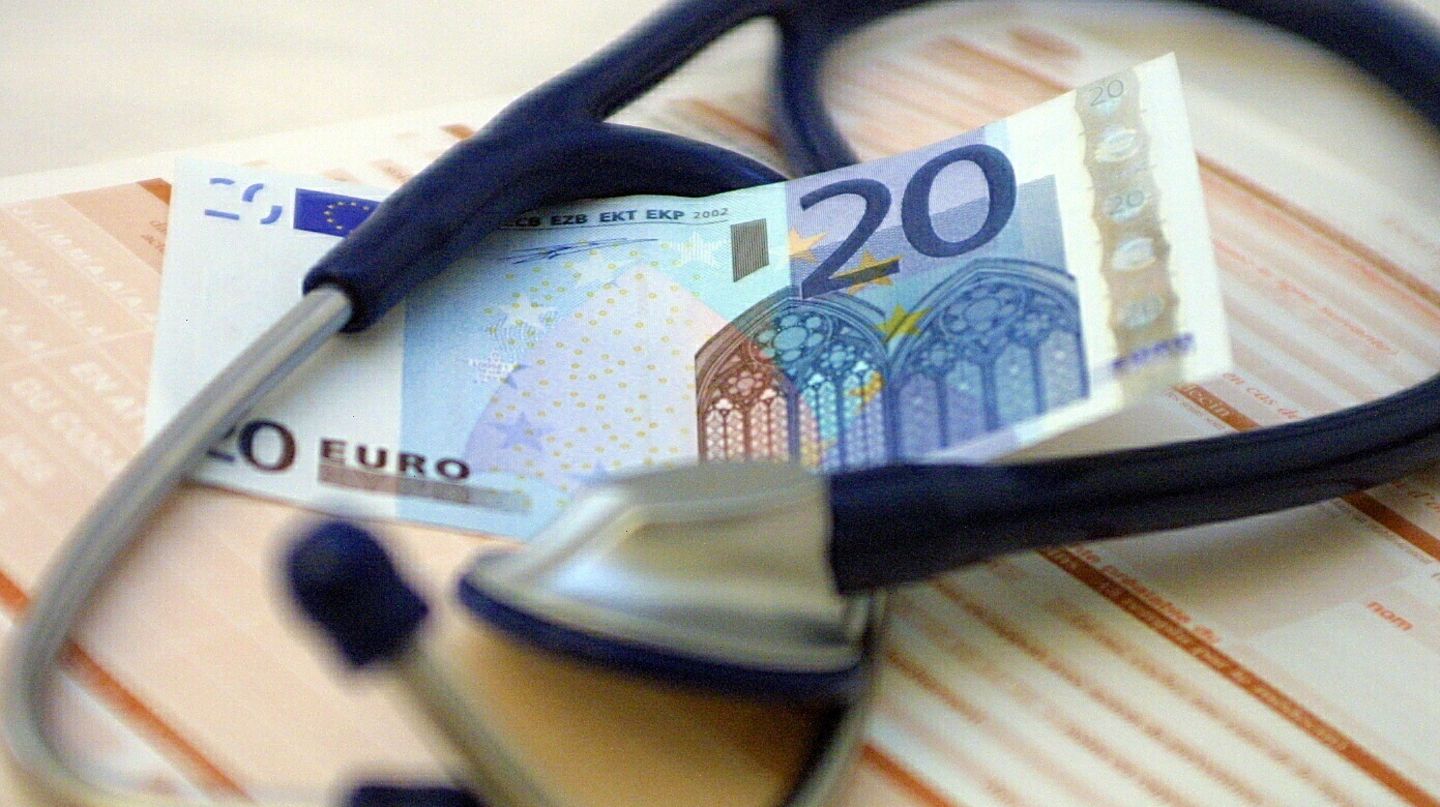 Ein Geldschein liegt neben einem Stethoskop