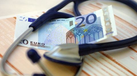 Ein Geldschein liegt neben einem Stethoskop