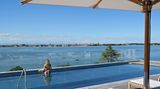 Rooftop-Pool mit Badegast und Blick auf die Lagune von Venedig