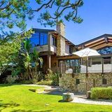 Das Haus ist umgeben von Palmen und Bäumen.