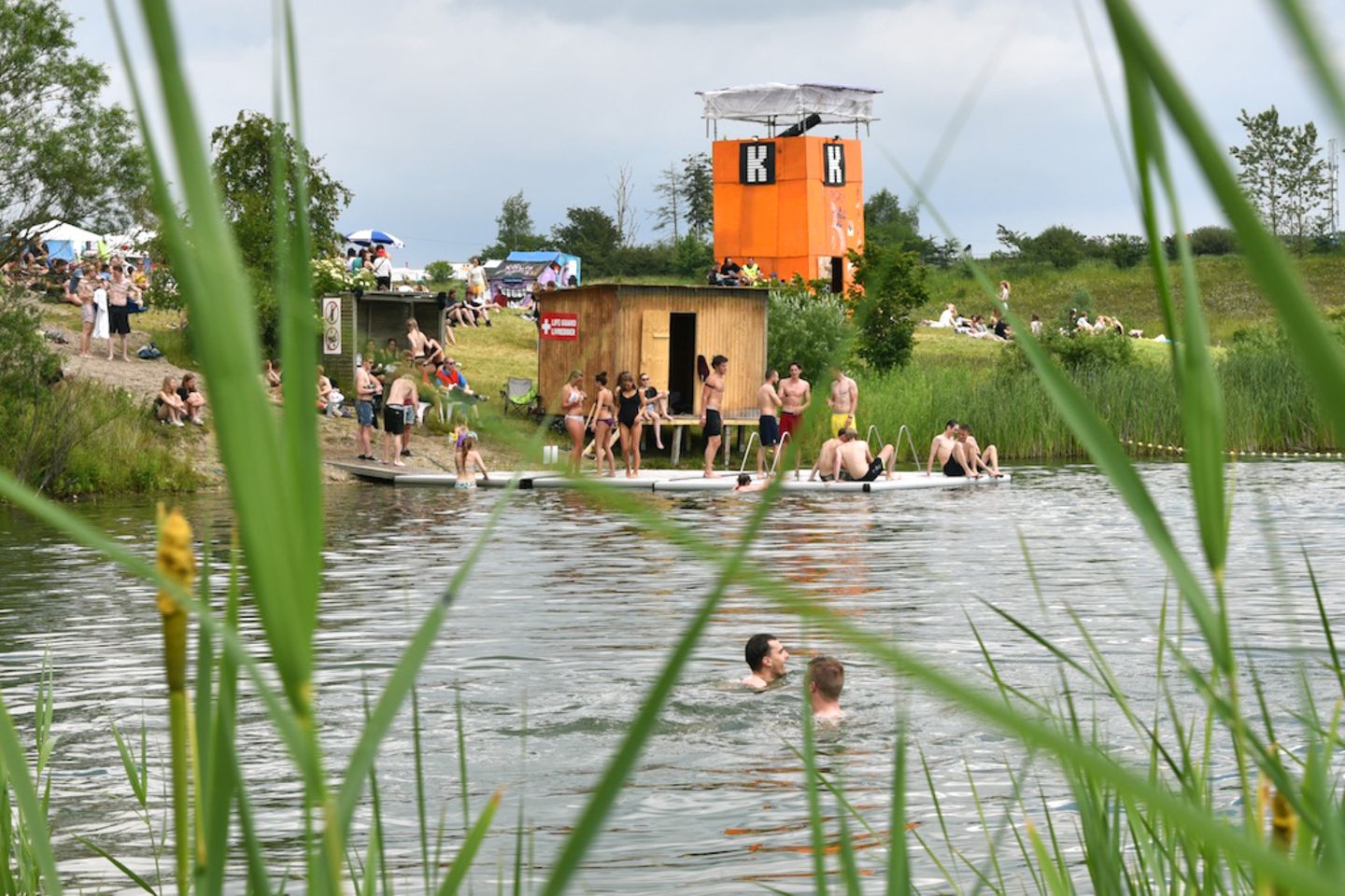 Roskilde-Festival 2015: Ein großer Teil des Campingeländes befindet sich auf einer renaturalisierten Kiesgrube. Der Baggersee bietet eine willkommene Erfrischung, auch wenn die skandinavische Wassertemperatur dafür sorgt, dass Warmduscher eher die kostenpflichtigen Brausen bevorzugen. Ein großer Teil des Campingeländes befindet sich auf einer renaturalisierten Kiesgrube. Der Baggersee bietet eine willkommene Erfrischung, auch wenn die skandinavische Wassertemperatur dafür sorgt, dass Warmduscher eher die kostenpflichtigen Brausen bevorzugen.