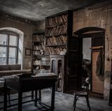 Raum mit Tisch, Stuhl und Bücherregalen