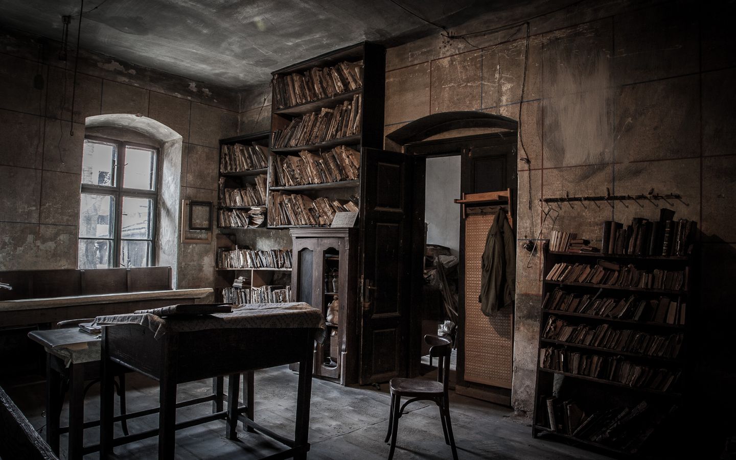 Raum mit Tisch, Stuhl und Bücherregalen