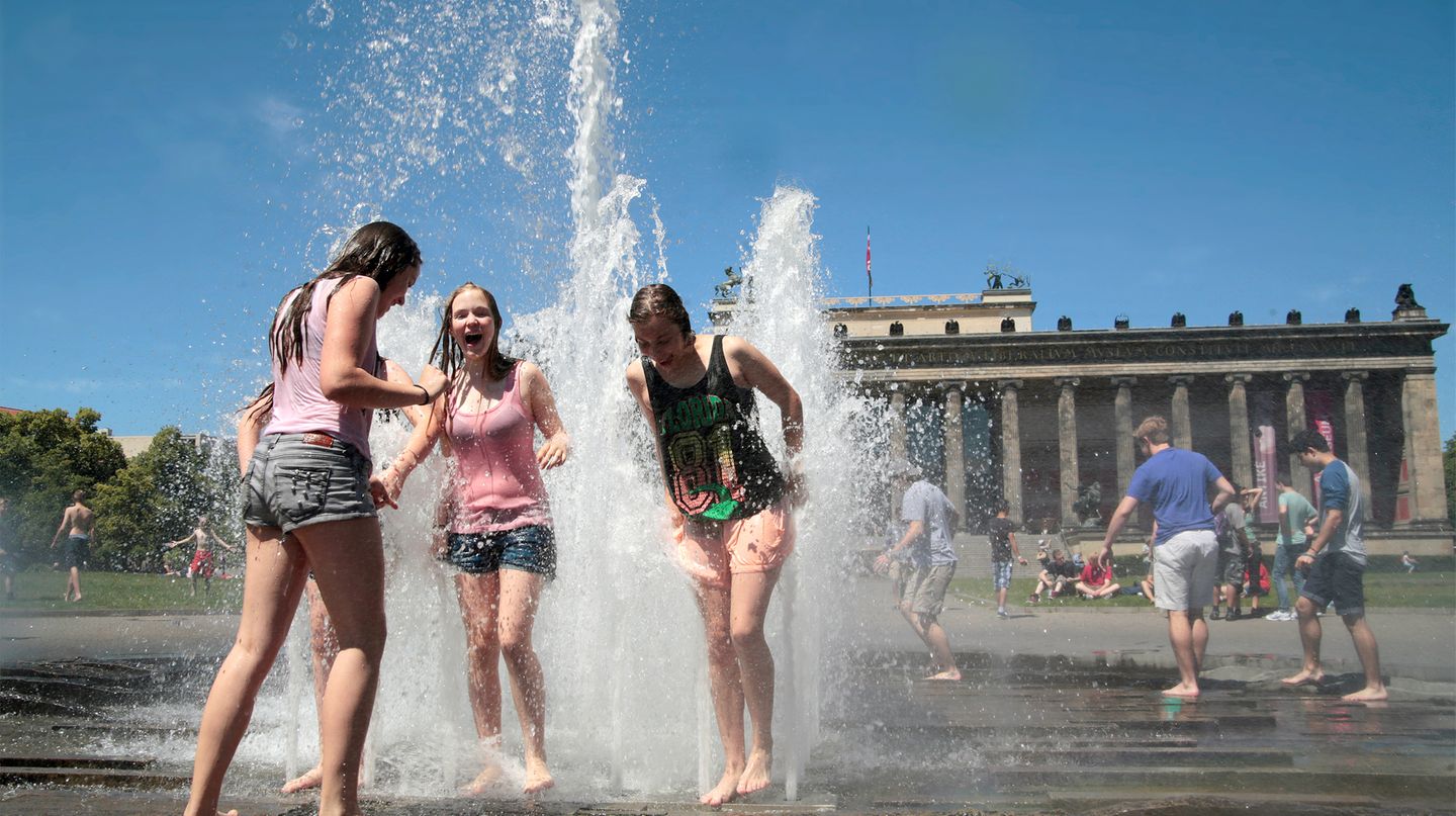 Hitze in Berlin: Kinder spielen vor dem Brandenburger Tor in einer Wasserfontäne