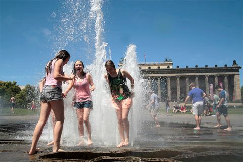 Hitze in Berlin: Kinder spielen vor dem Brandenburger Tor in einer Wasserfontäne