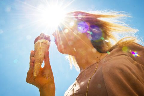 An einem heißen Sommertag genießt eine junge Frau ein Eis