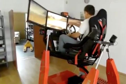 Auf pneumatische Pumpen sind ein Sitz und drei Bildschirme montiert. Die Pumpen simulieren die Bewegungen in einem Computerspiel