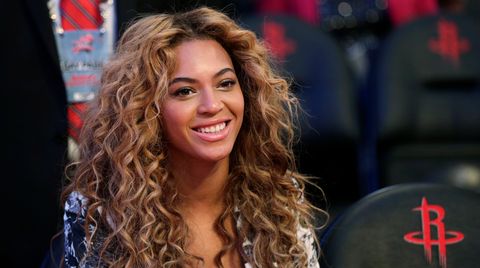 Sängerin Beyoncé  trägt ein tief ausgeschnittenes silbernes Kleid, ihr wallenden Locken ragen bis zu den Oberarmen