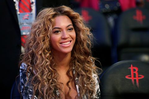 Sängerin Beyoncé  trägt ein tief ausgeschnittenes silbernes Kleid, ihr wallenden Locken ragen bis zu den Oberarmen