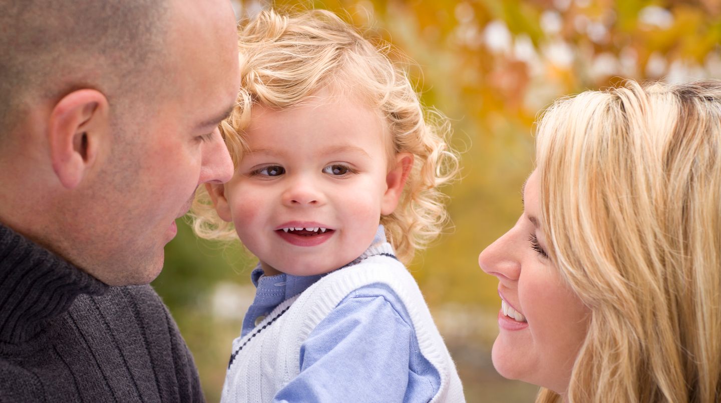 Mama und Papa strahlen ihr Kind an