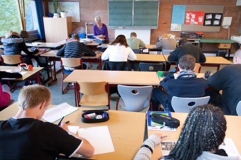 Schüler sitzen konzentriert an ihren Pulten
