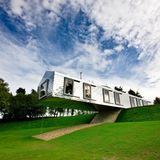 Das schlicht gehaltene ebäude ragt zur Hälfte über den Hang, auf dem es gebaut wurde.