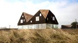 Das Dune House wirkt, als ob das Dach über dem voll-verglasten Erdgeschoss schweben würde.