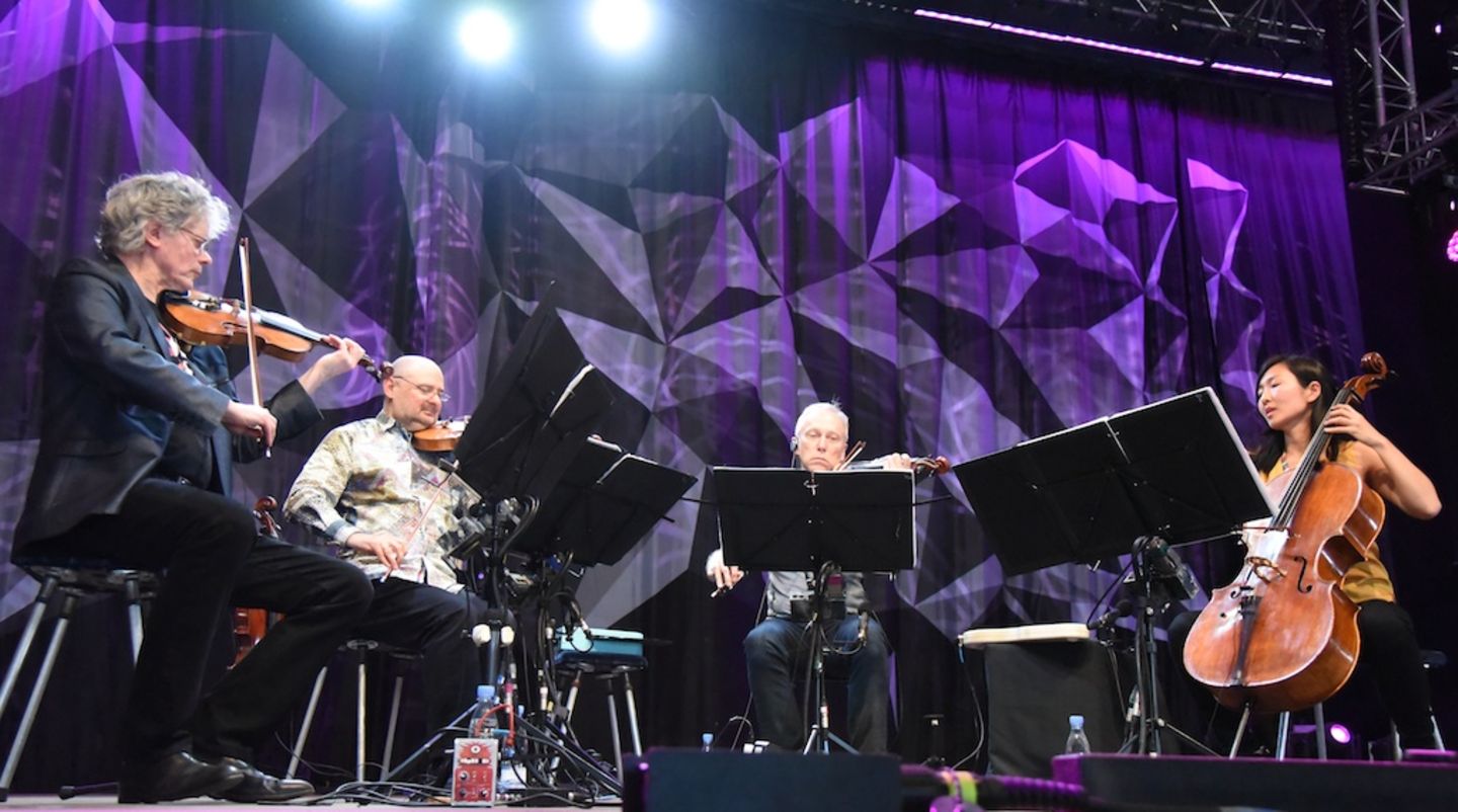 Roskilde Festival 2015: Obwohl es erst zwölf Uhr ist als das "Krinis Quartetta" am Freitag Mittag die Bühne betritt ist das Avalon-Zelt bereits gut gefüllt. Die frühen Besucher lauschen andächtig und applaudieren frenetisch. Die Zugabe nach einer Komposition von Jimi Hendrix scheint wie eine Hommage an Roskilde und die Festival-Kultur im Allgemeinen. Obwohl es erst zwölf Uhr ist als das "Krinis Quartetta" am Freitag Mittag die Bühne betritt ist das Avalon-Zelt bereits gut gefüllt. Die frühen Besucher lauschen andächtig und applaudieren frenetisch. Die Zugabe nach einer Komposition von Jimi Hendrix scheint wie eine Hommage an Roskilde und die Festival-Kultur im Allgemeinen.