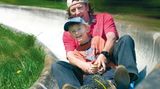 Ein Vater fährt mit seinem Sohn die Sommerrodelbahn in St. Andreasberg im Harz hinab
