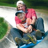 Ein Vater fährt mit seinem Sohn die Sommerrodelbahn in St. Andreasberg im Harz hinab
