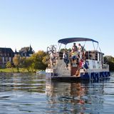Ein Hausboot fährt auf der Müritz vor Schloss Klink vorbei