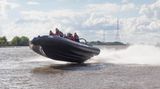 Ein Schlauchboot rast mit Höchstgeschwindigkeit über die Elbe