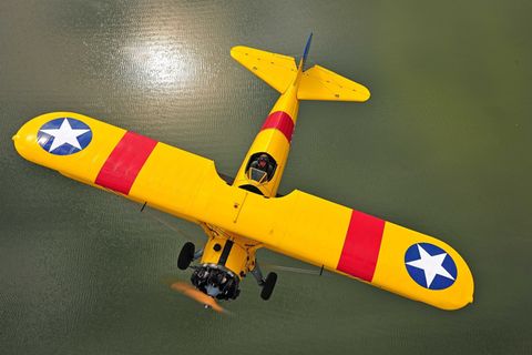 Eine Boeing Stearman fliegt über offenes Wasser