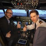 Flugschüler und Pilot grüßen aus dem Flugsimulator einer Boeing 737-700