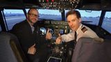 Flugschüler und Pilot grüßen aus dem Flugsimulator einer Boeing 737-700