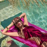 Die Palmen werfen weiche Schatten über ihren Körper. Blohm trägt einen Bikini von Hermès. 