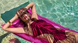 Die Palmen werfen weiche Schatten über ihren Körper. Blohm trägt einen Bikini von Hermès. 