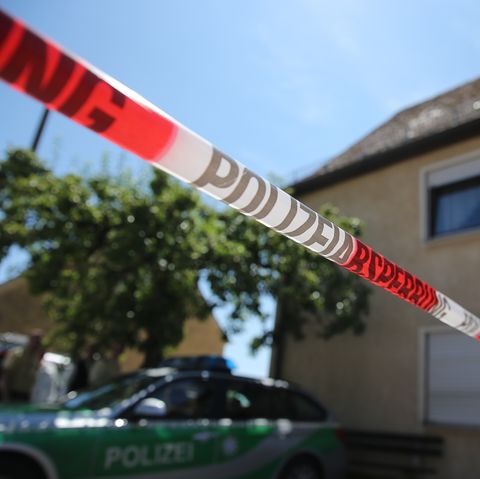 Ein Polizeifahrzeug steht am in Leutershausen bei Ansbach an einem abgesperrten Tatort.