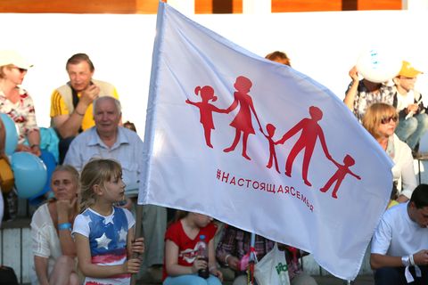 Ein Mädchen hält die neue russische Familien-Flagge in die Höhe