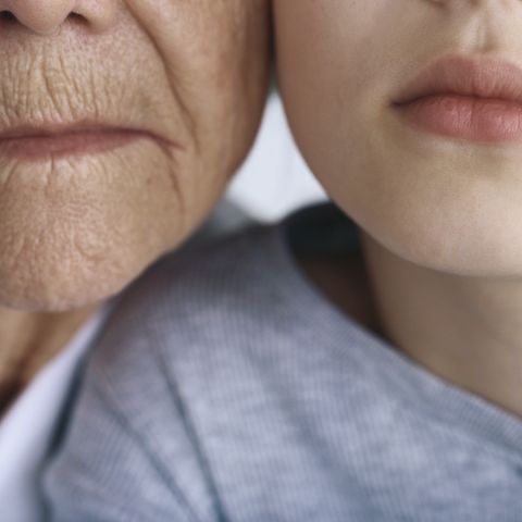Eine alte Frau und ein junges Mädchen Wange an Wange