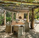 Der Außenkamin wird von einer schattenspendenden Pergola überdacht.