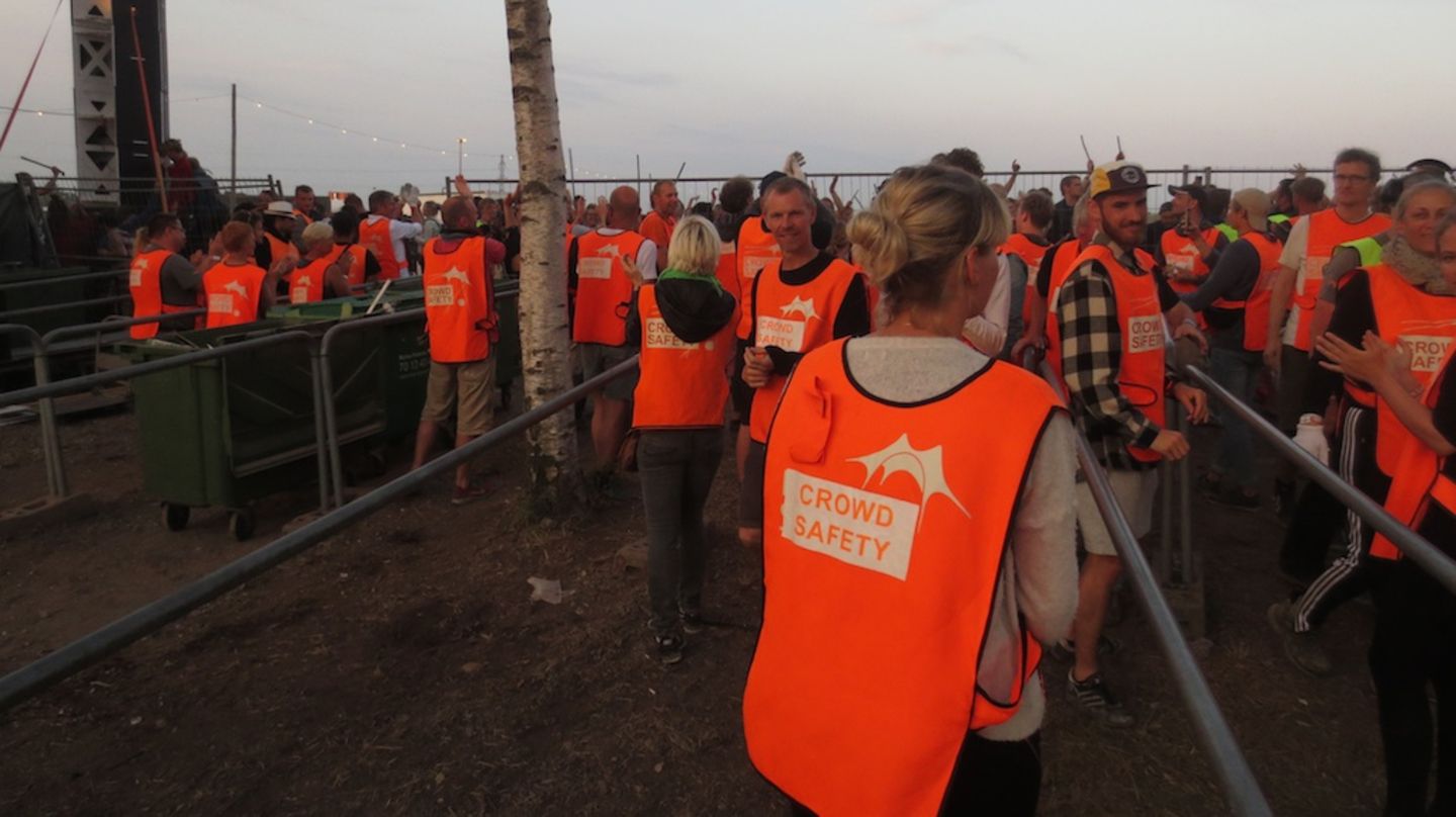 Nicht nur Damon Albarn mit dem "Africa Express" musste von der Bühne getragen werden... Auch ein Teil der Festival Besucher ist mit dem Ende des Roskilde Festivals 2015 überhaupt nicht einverstanden. Traditionell wird stundenlang weitergemacht, indem die Feierwütigen mit Stöcken, Zeltstangen und allem auffindbaren gegen alles trommeln was Lärm macht. Zwischedurch applaudieren Crowd Safety und Publikum sich gegenseitig – wobei ja generell nur die orangene Weste darüber entscheidet auf welcher Seite des Zauns man sich zu diesem Zeitpunkt befindet. Entweder man hat gerade Schicht oder eben nicht.