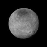 Schwarz-Weiß-Aufnahme von Charon mit dunklem Nordpol und Schluchten