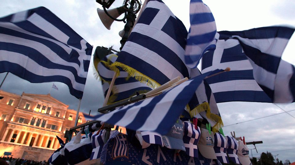 Griechische Fahnen wehen auf dem Syntagma-Platz vor dem Parlamentsgebäude in Athen.