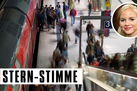 An einem Bahngleis strömen Menschen - verzerrt unkenntlich gemacht - hin und her, auf die Rolltreppe, in einen Zug hinein.