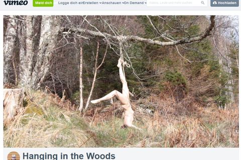 Die Künstlerin Hilde Krohn Huse hängt nackt an einem Baum