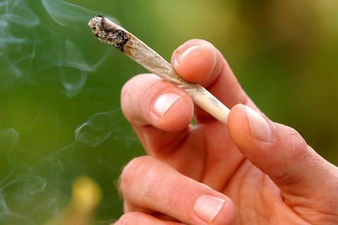 Ein Mann hält einen Joint in der Hand