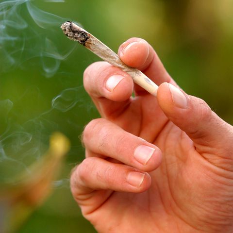Ein Mann hält einen Joint in der Hand