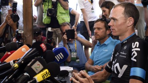 Christopher Froome sitzt vor Mikrofonen, umringt von Fotografen