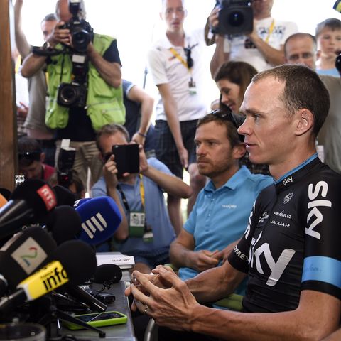 Christopher Froome sitzt vor Mikrofonen, umringt von Fotografen