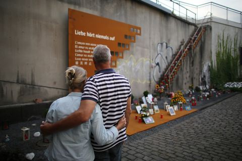 An der Gedenkstätte für die 21 Toten der Loveparade 2010 in Duisburg steht am 5. Jahrestag des Unglücks ein Paar Arm in Arm.