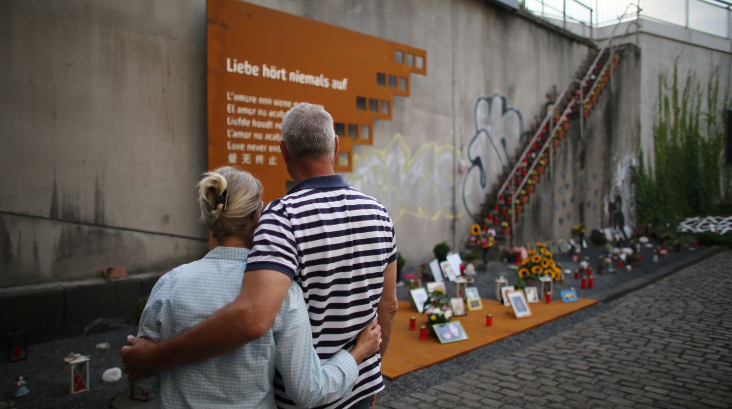 An der Gedenkstätte für die 21 Toten der Loveparade 2010 in Duisburg steht am 5. Jahrestag des Unglücks ein Paar Arm in Arm.