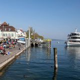 Bodensee - Ein Hauch von Italien  Der Ausblick macht still: ringsum der Wein, vor einem der Weißburgunder, eiskübelkühl perlend. Über den Bodensee ziehen Segelboote, der leise Wind weht über sie hinweg ins Schweizer Hügelland. Man horcht: kein Auto, nur Vögel. Von der Terrasse des Weinguts Aufricht zum Seeufer geht der Blick über Rebland. Kaum zu glauben: Dies ist nicht Italien.  www.aufricht.de  Auf der Lokalpatrioten-Karte anschauen